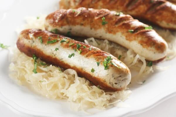 Bratwurst on Sauerkraut on a White Plate
