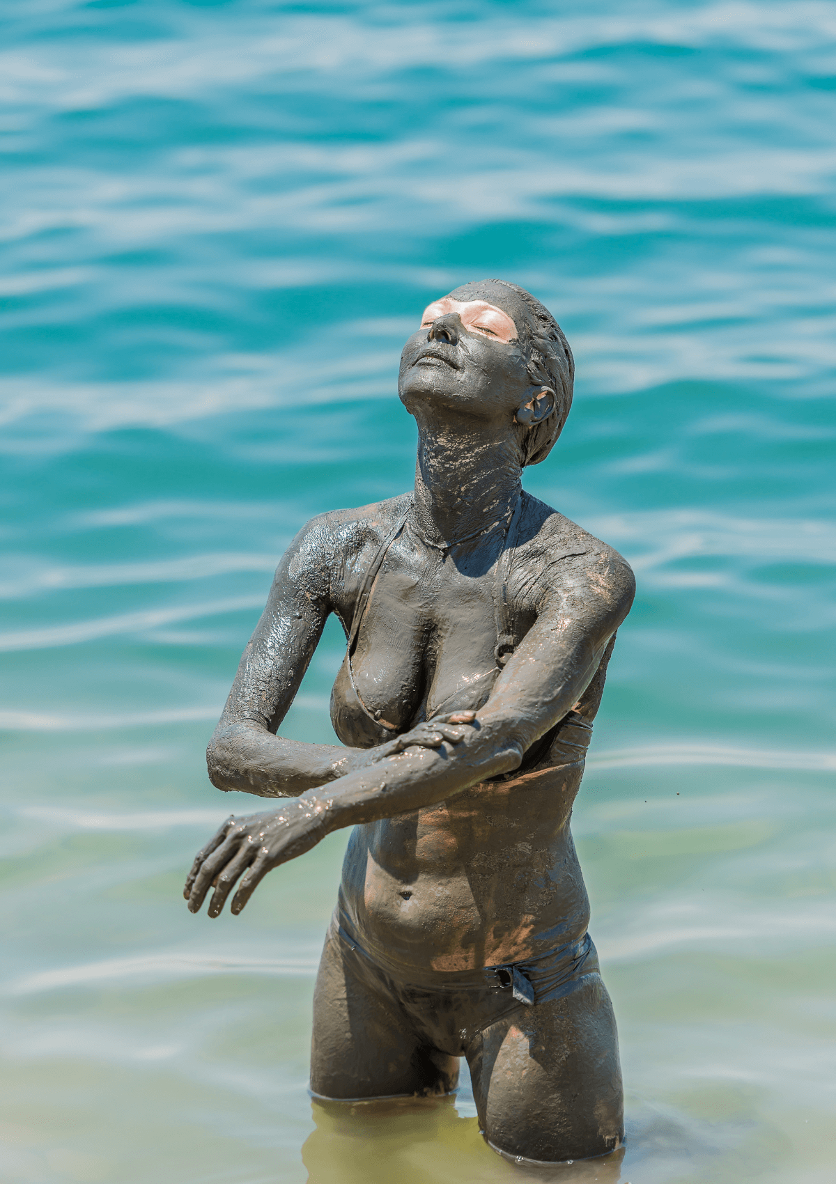 Woman covered in mud in the Dead Sea in Jordan - skincare products as Jordanian souvenirs